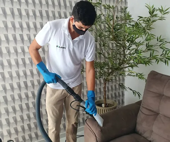Profissional da PROLAVE higienizando uma poltrona durante atendimento em domicílio